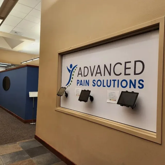 The APS check-in wall with the logo panel and tablet kiosks