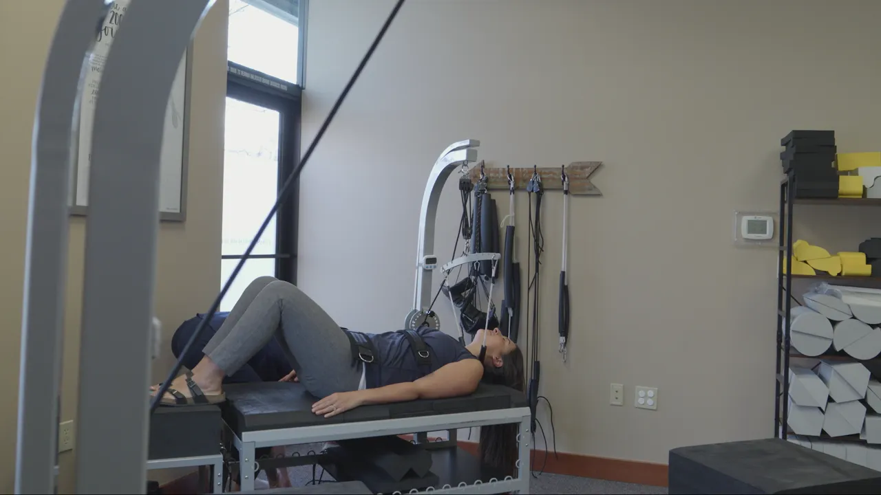 A patient lies on the clinic's spinal decompression table in the Redmond treatment room, fitted with the harness