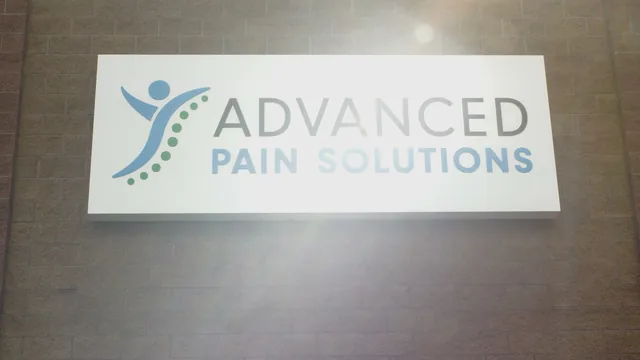 The Advanced Pain Solutions logo sign on a stone wall inside the Redmond clinic