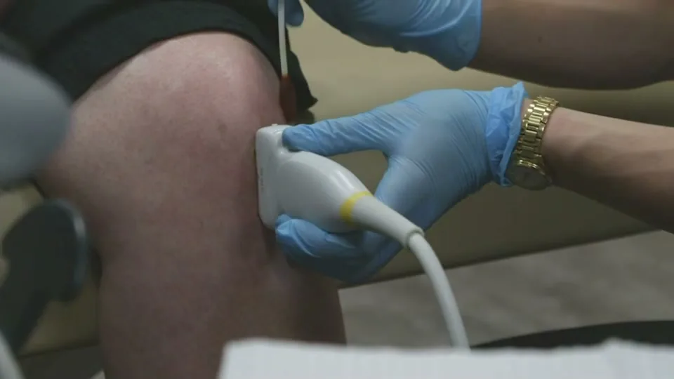 An ultrasound probe is placed on a patient's knee at Advanced Pain Solutions