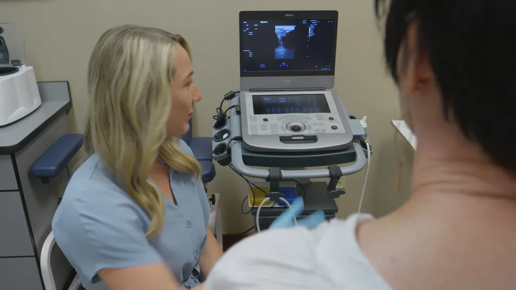 An ultrasound machine shows a live image beside the treatment chair